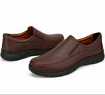 A pair of men's slip-on loafers in dark brown faux leather with black soles, displayed on a clean white background.